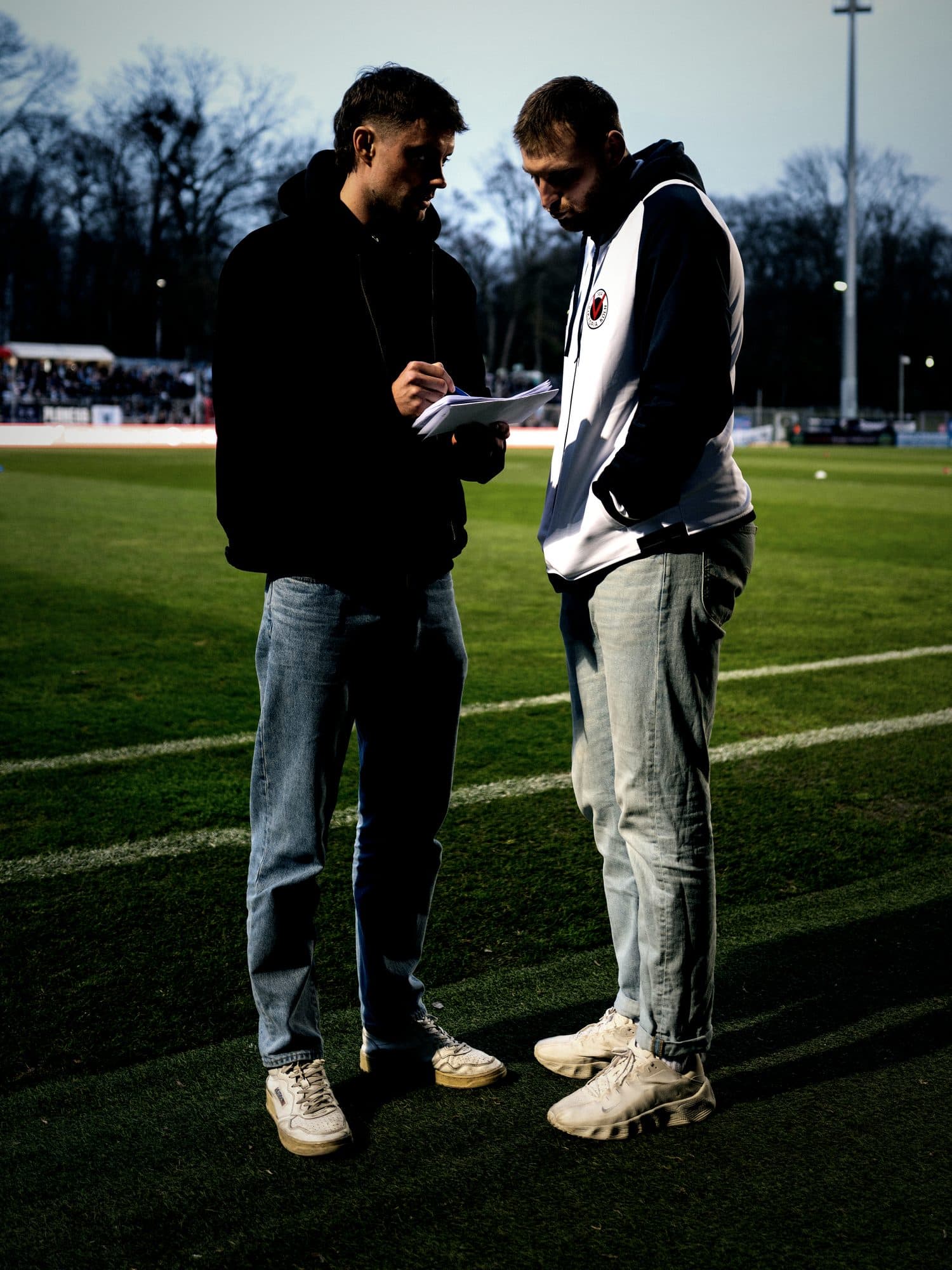 Pipo Konrad im Austausch mit einem Trainer am Spielfeldrand
